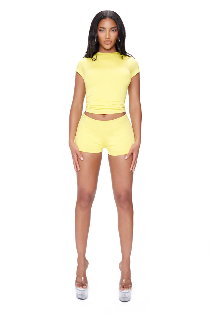 Woman wearing a yellow outfit on a white background