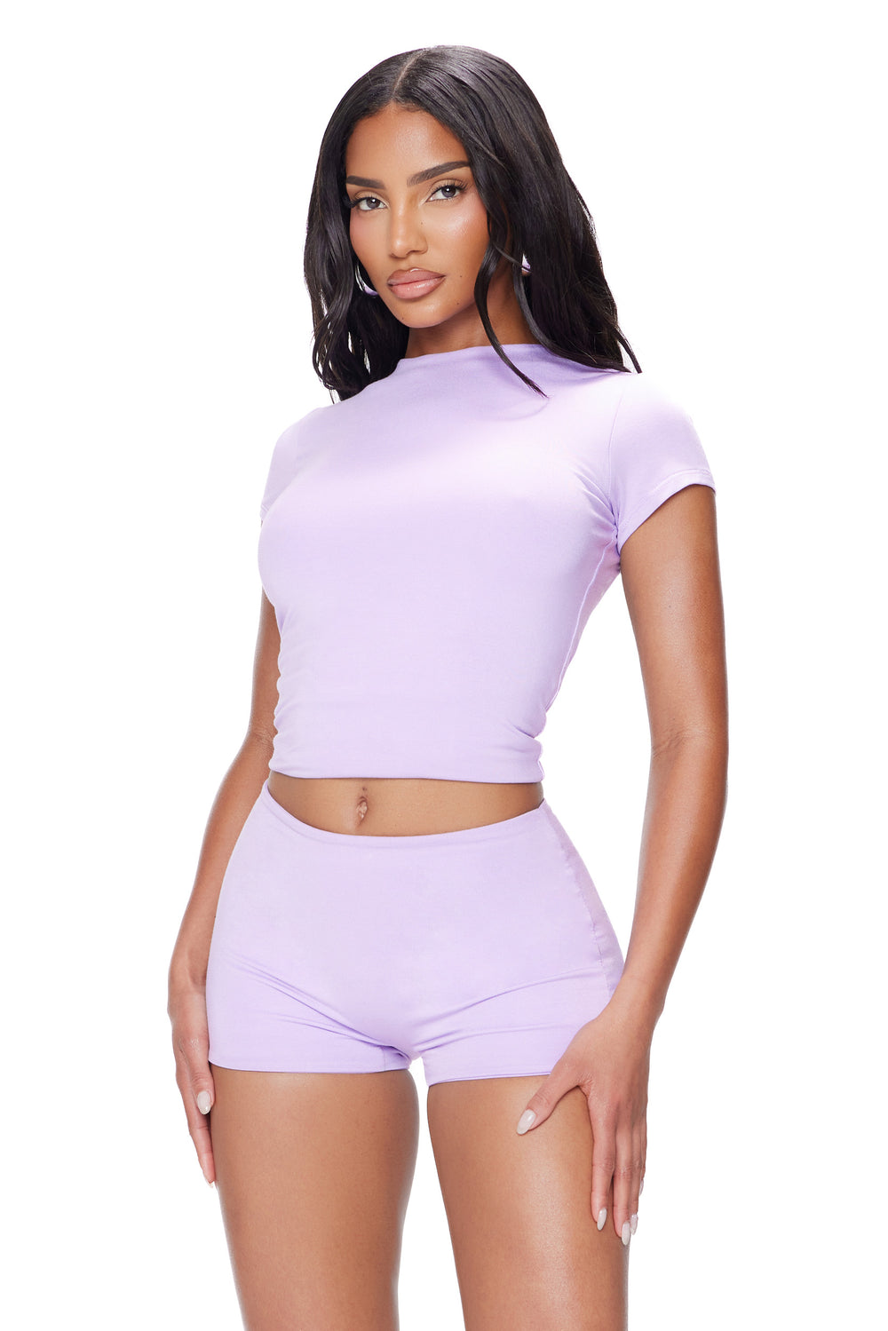 Woman wearing a matching lavender top and shorts set on a white background