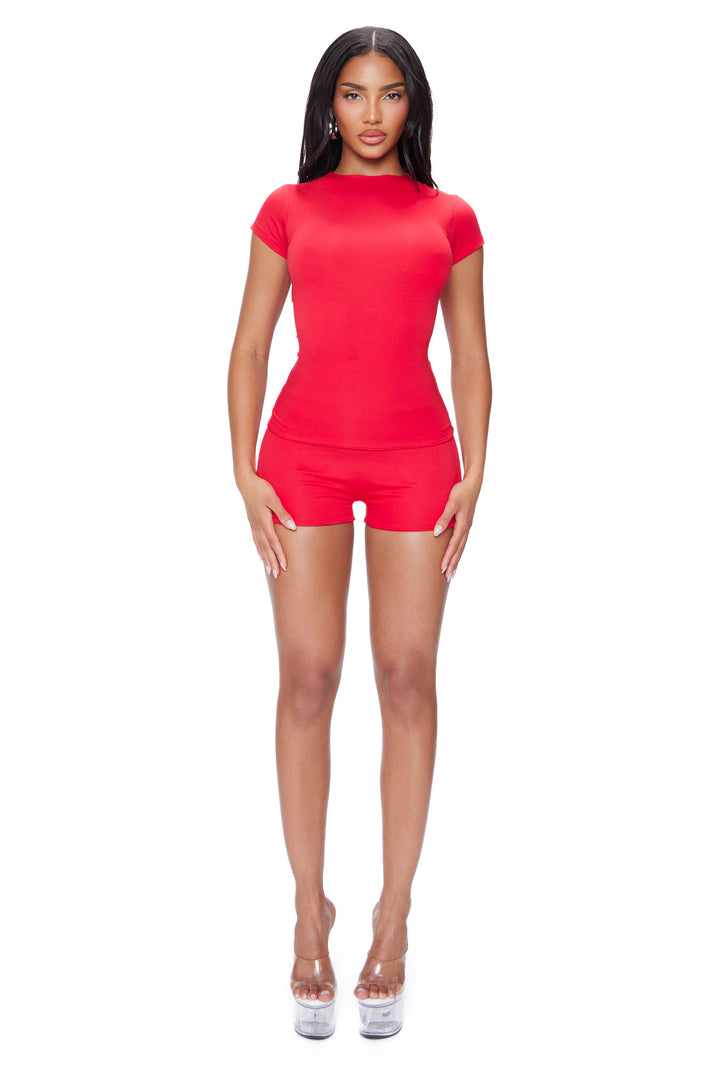 Woman wearing a red super soft outfit on a white background