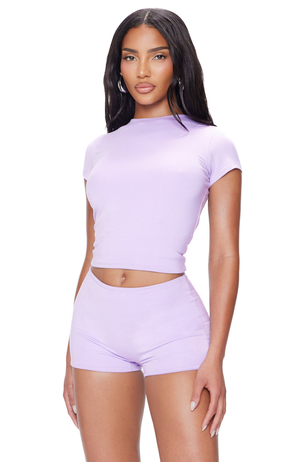 Woman wearing a matching lavender orchid top and shorts set on a white background
